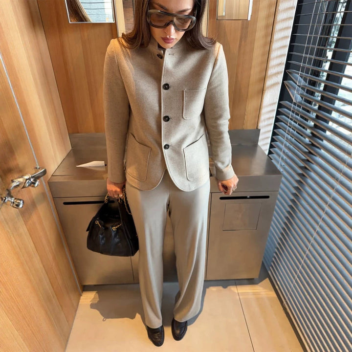 Women's tailored jacket blazer made of wool mix with stand-up collar, curved hem, and patch pockets.