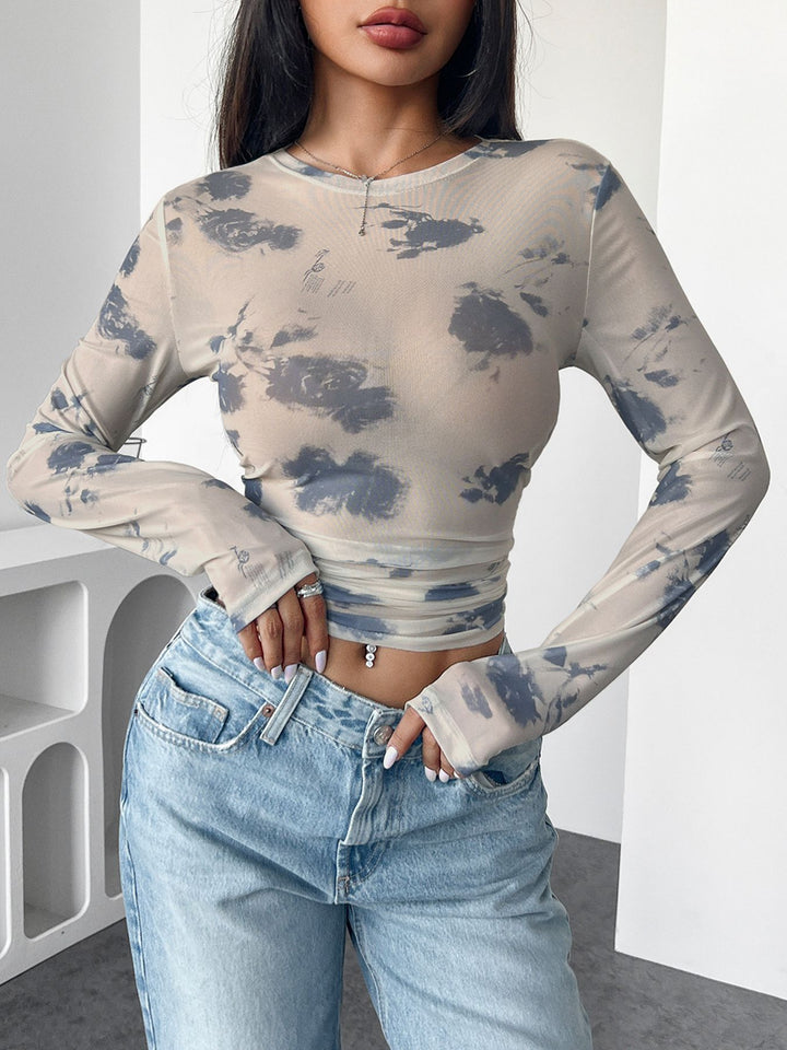 Women's form-fitting tailored crop mesh top with round neck, extended sleeves, thumb holes, and subtle tie-dye pattern Mune Fashion
