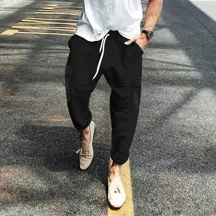 Men's corduroy cargo jogging pants with elastic drawstring waistband, flap pockets, and tapered leg Mune Fashion