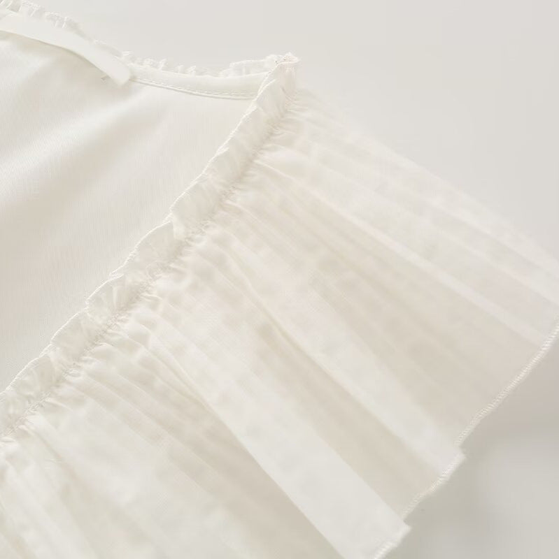 Ladies sleeveless ruffle blouse with deep V-neck, delicate pleated ruffle and tie bow detail