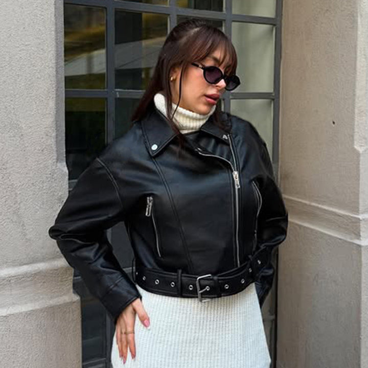 Women's fitted biker jacket made of faux leather with asymmetrical zipper, metallic details, and waist belt Mune Fashion