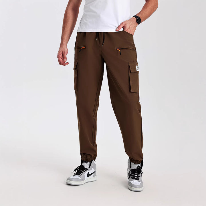 Men's tapered cut utility cargo pants in jogger style with drawstring waistband, zippered pockets & elastic leg cuffs Mune Fashion