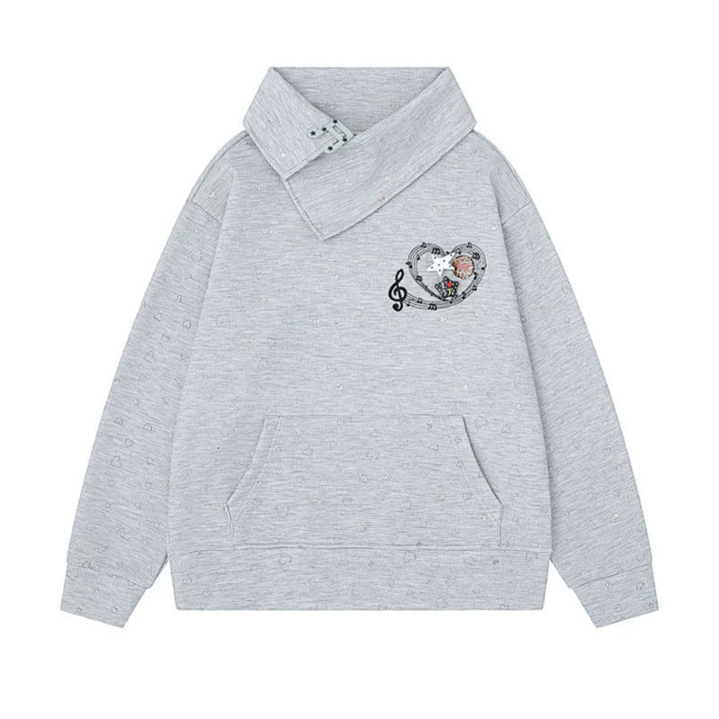 Women’s oversized sweatshirt with asymmetrical stand-up collar, kangaroo pocket and musical heart embroidery Mune Fashion