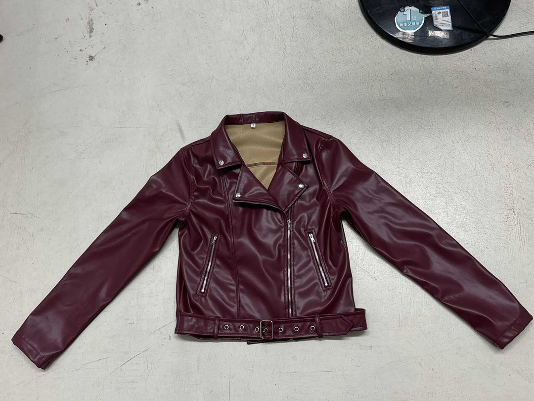 Women's fitted biker jacket made of faux leather with asymmetrical zipper, metallic details, and waist belt Mune Fashion