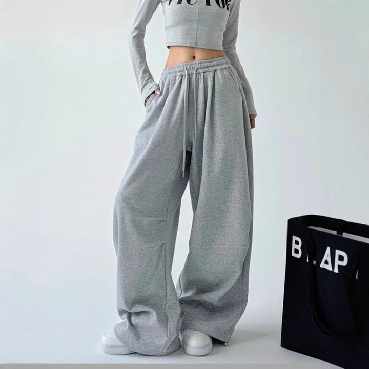 Women's loose-fitting high-waist lounge pants with elastic waistband, drawstring, and side pockets.