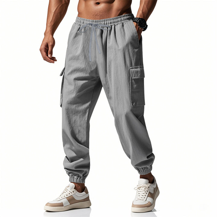 Men's tapered joggers in utilitarian style with elastic waistband, drawstring, and flap pockets Mune Fashion