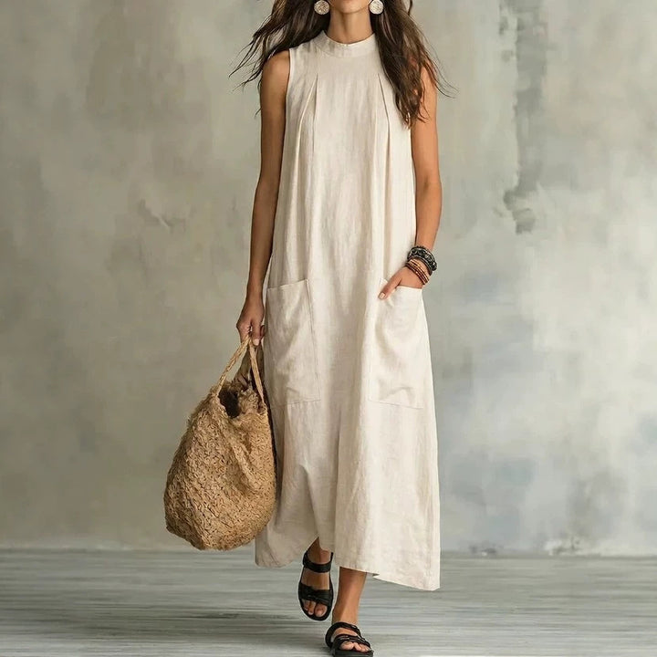 Women’s sleeveless linen maxi dress with standing collar, pleats at the chest, and piled pockets Mune Fashion