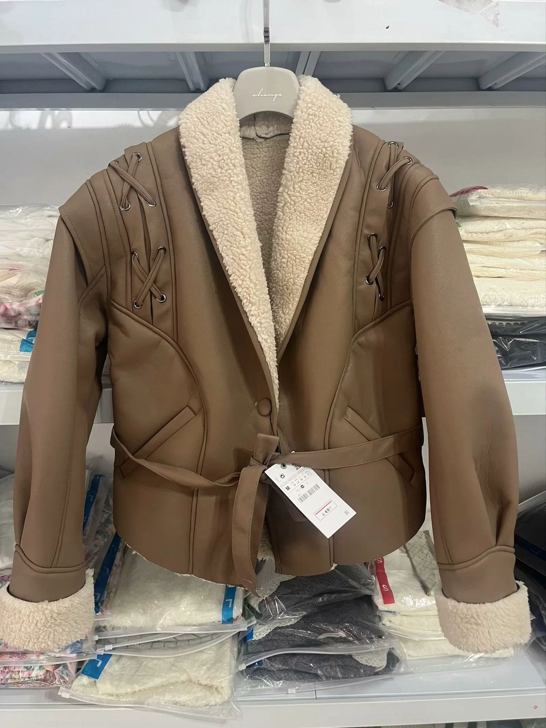 Women's tailored faux leather jacket with Sherpa lining, wrap belt, and side lacing details Mune Fashion