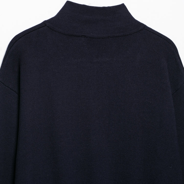 Women's cropped fine-knit cardigan with standing collar, full-length zipper, and fitted ribbed section.
