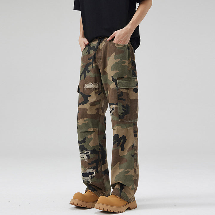 Men's loose cargo pants in camouflage look with deliberately ripped details and large flap pockets Mune Fashion