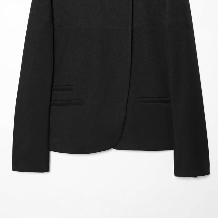 Women’s short-cut blazer with stand-up collar, asymmetrical closure, and piping pockets Mune Fashion