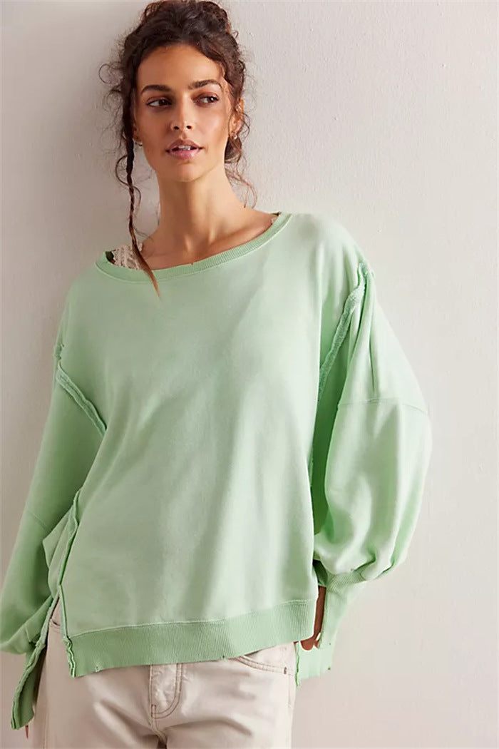 Women's oversized sweatshirt with balloon sleeves, open seam stitches, and side slits Mune Fashion