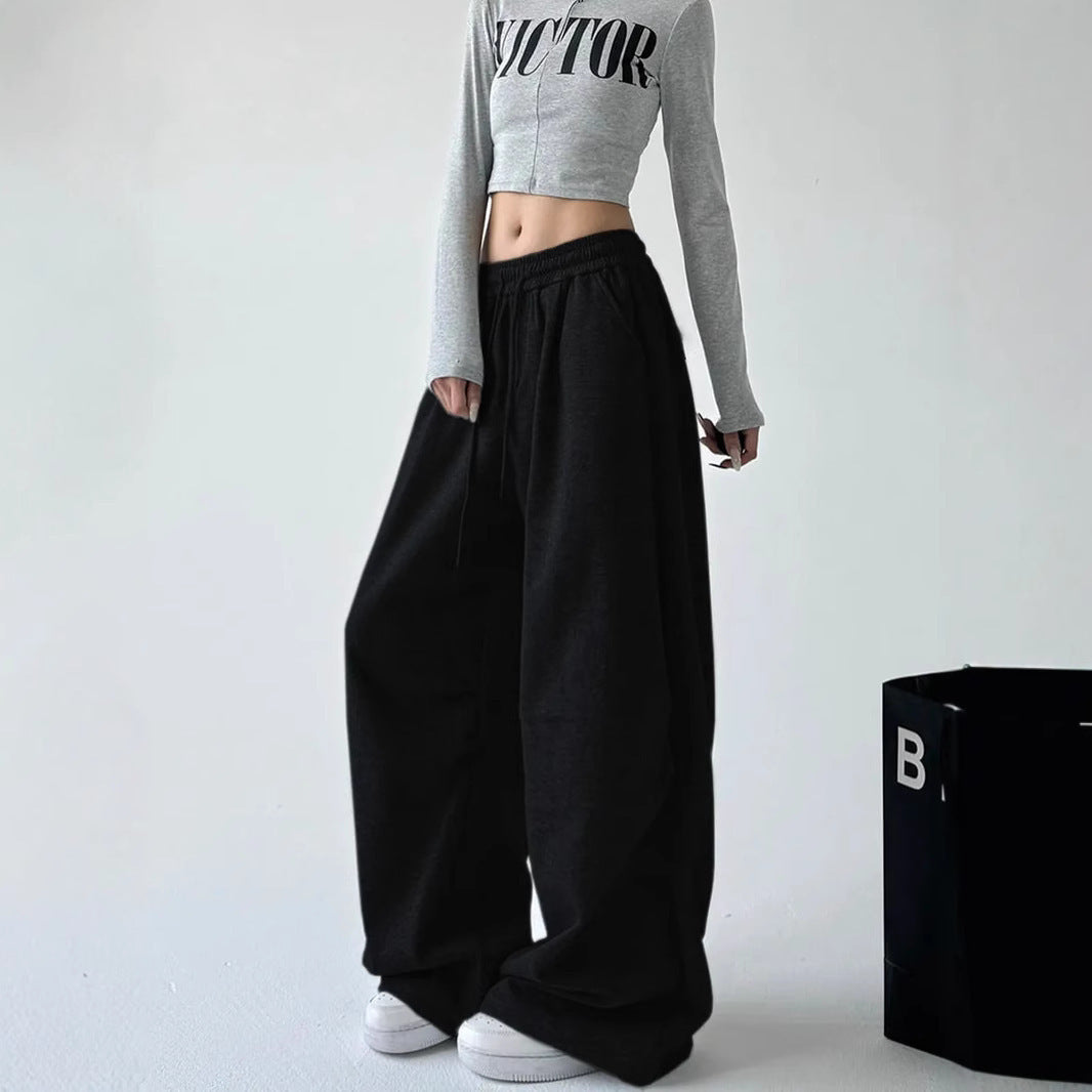 Women's loose-fitting high-waist lounge pants with elastic waistband, drawstring, and side pockets.