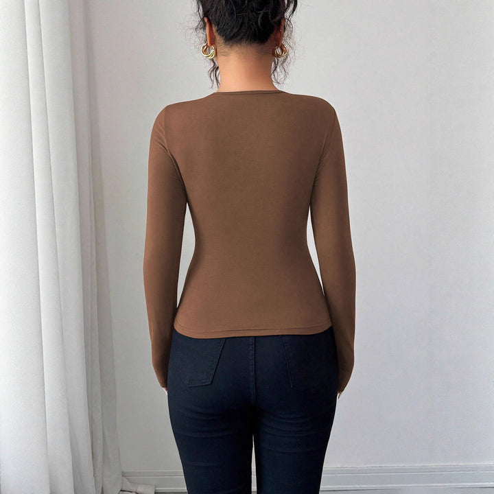 Women's form-fitting long-sleeve shirt with decorative ring detail and asymmetrical keyhole neckline Mune Fashion