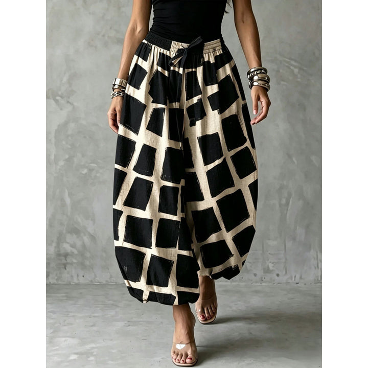 Women's wide harem pants in balloon style with elastic waistband and graphic check pattern Mune Fashion