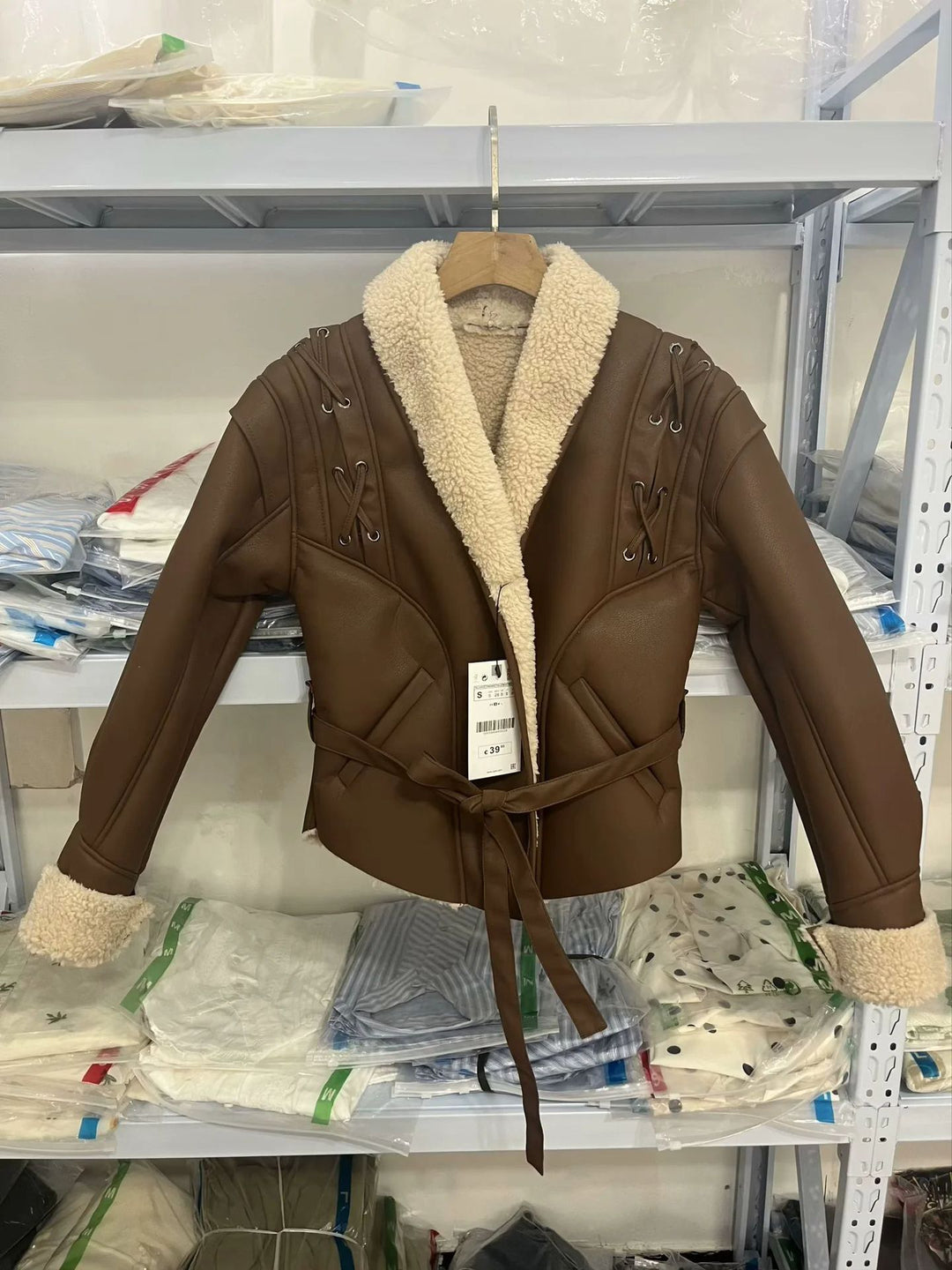 Women's tailored faux leather jacket with Sherpa lining, wrap belt, and side lacing details Mune Fashion