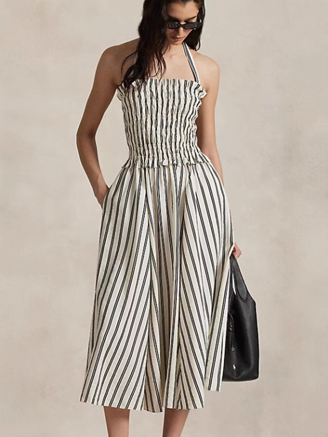 Women's midi dress with smocked bodice, adjustable halter strap, wide A-line skirt and side pockets Mune Fashion