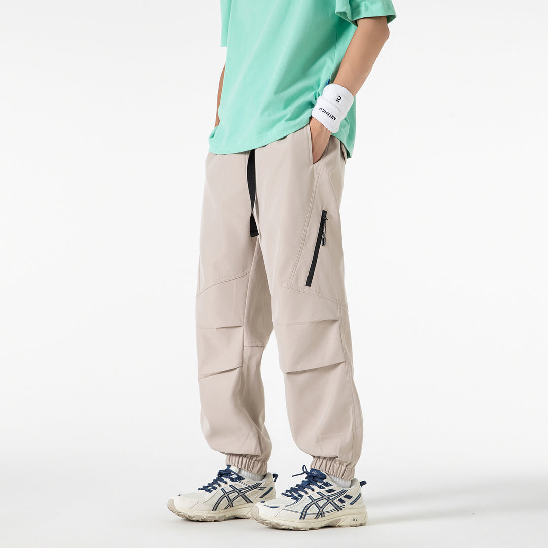Men's loose technical cargo jogger pants with elastic drawstring waistband, patch flap pockets, and zippered leg pocket Drune
