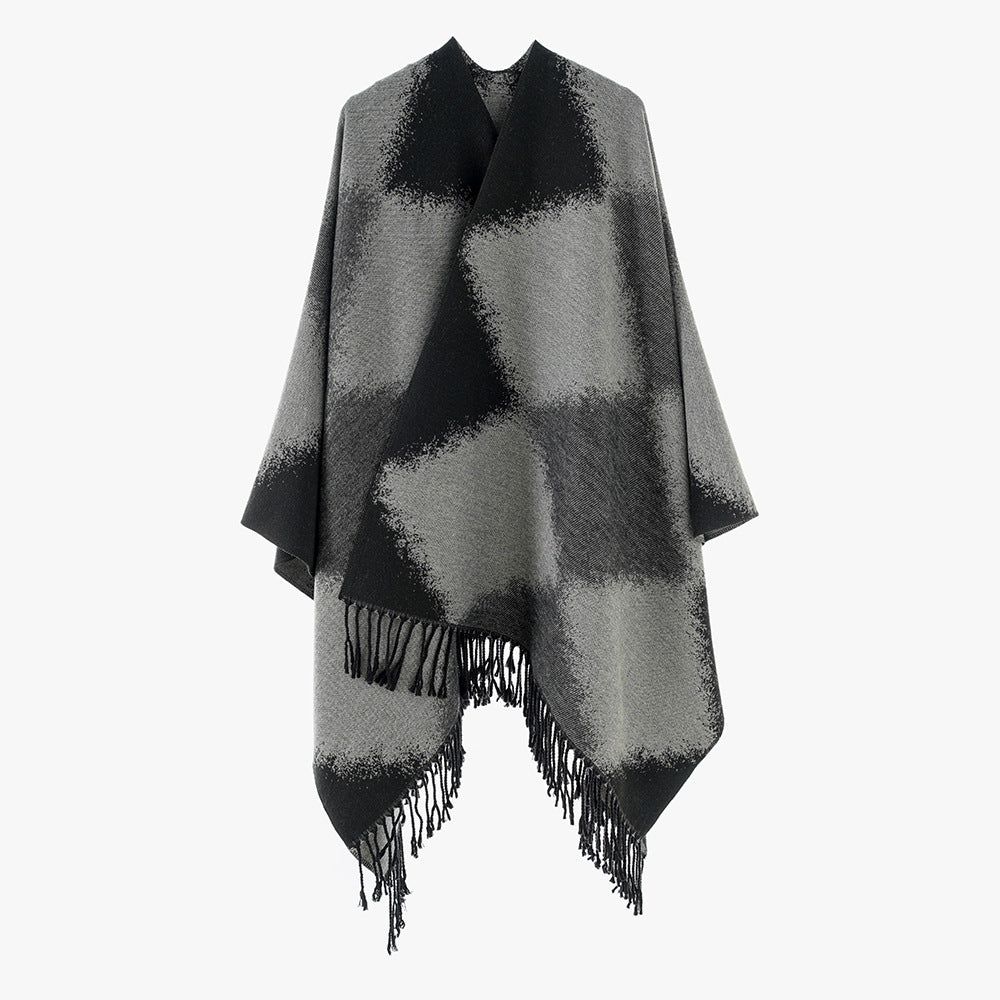 Women's cape poncho with softly falling wool blend quality, asymmetrical pointed hem and chain fringes.