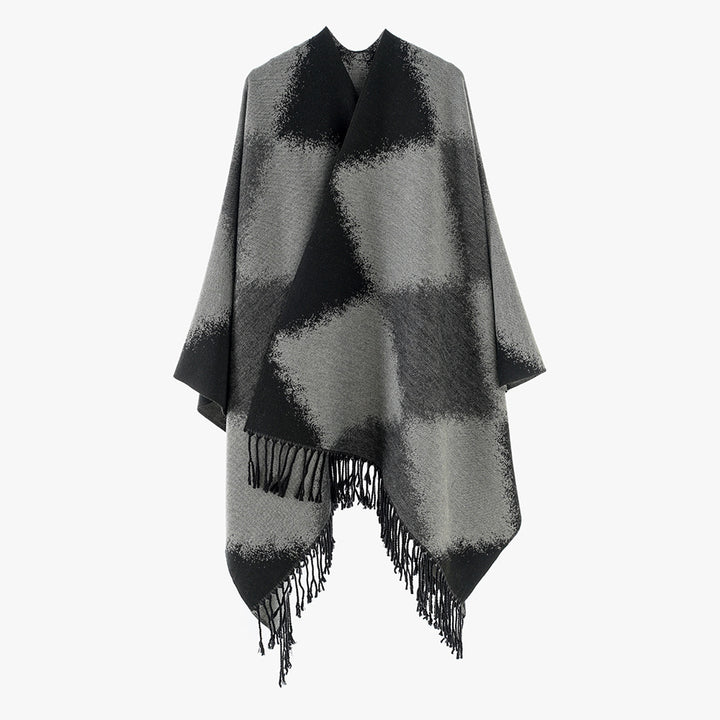 Women's cape poncho with softly falling wool blend quality, asymmetrical pointed hem and chain fringes.