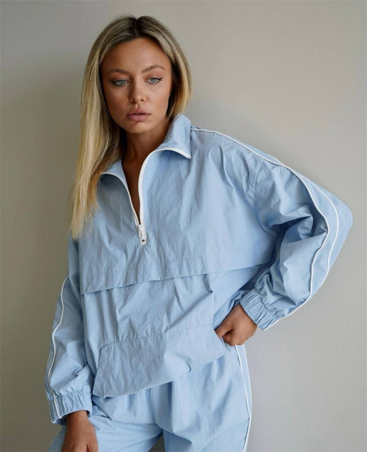 Women's lightweight half-zip windbreaker top with kangaroo pocket, elastic cuffs, and side piping Mune Fashion