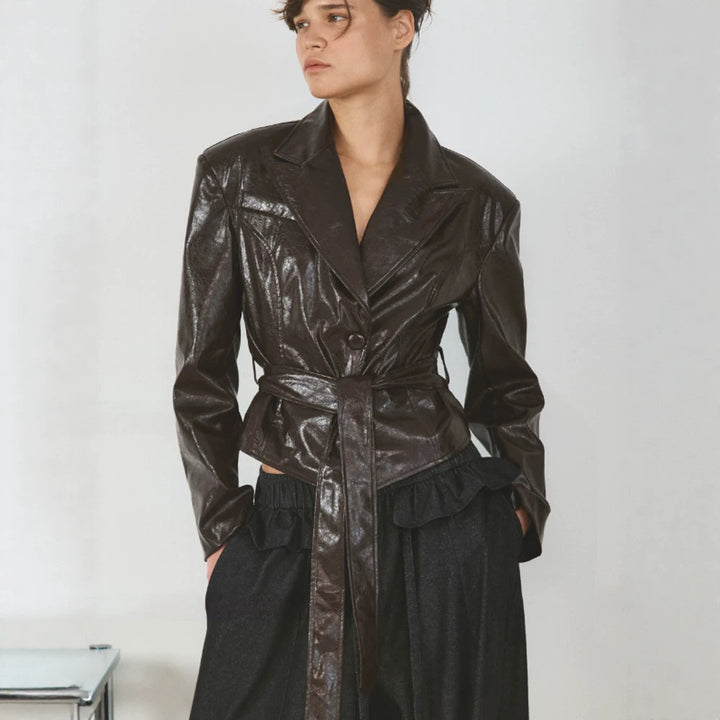 Women’s short blazer in patent leather look with waist belt and flowing lapel Mune Fashion