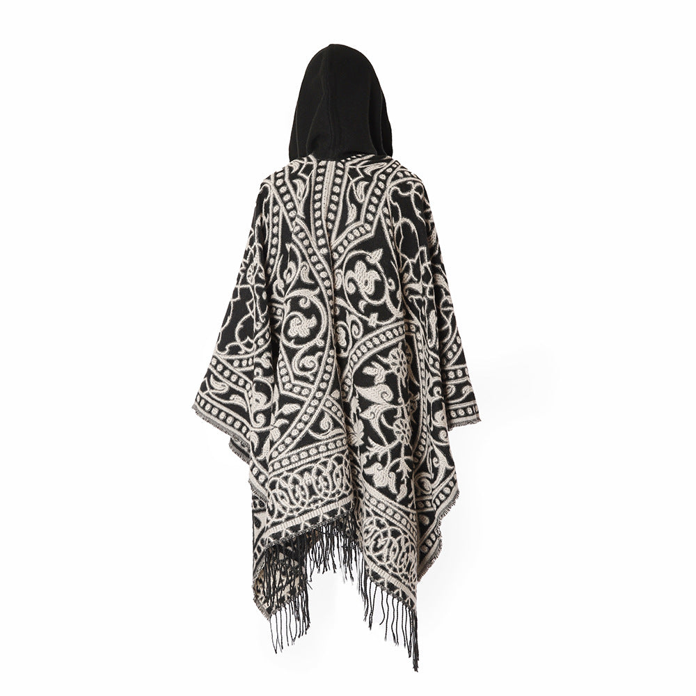 Women’s hooded cape poncho made of wool blend with jacquard pattern, fringes and oversized drape.