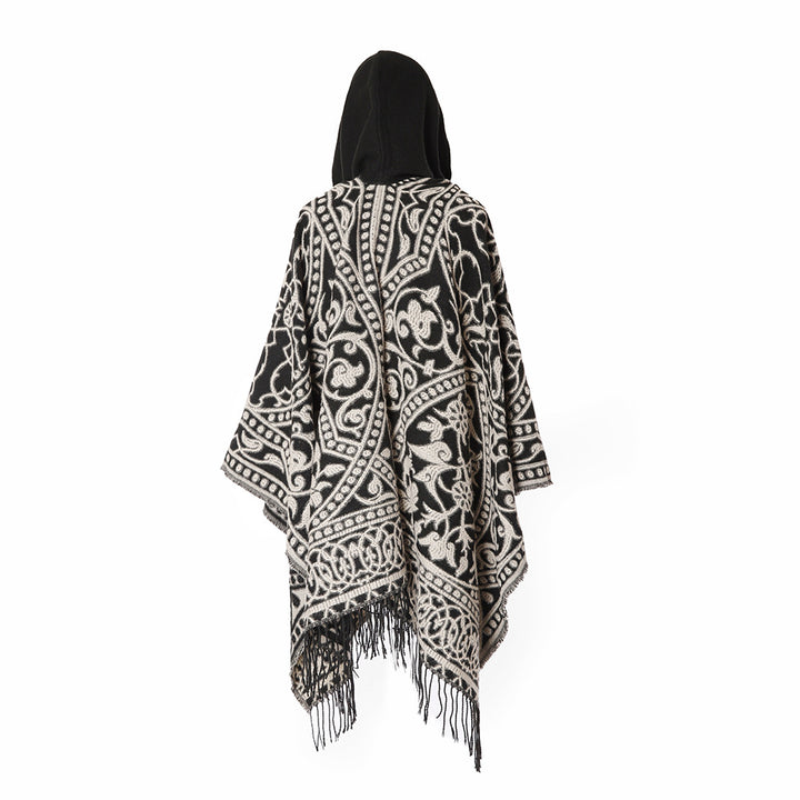 Women’s hooded cape poncho made of wool blend with jacquard pattern, fringes and oversized drape.