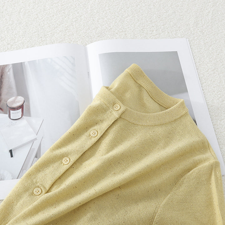 Women's fine round neck cardigan made of lightweight fine knit with pearl button placket and subtle glitter effect.