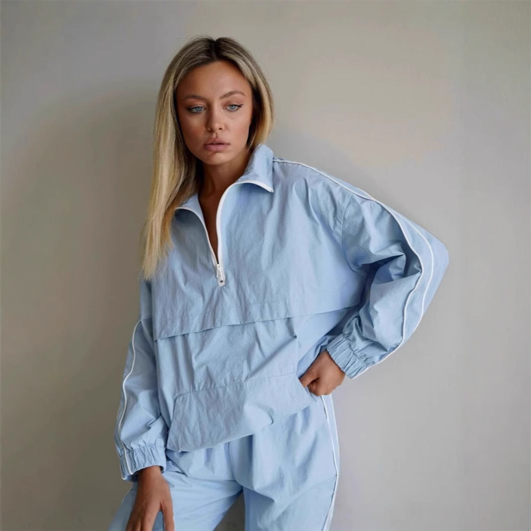 Women's lightweight half-zip windbreaker top with kangaroo pocket, elastic cuffs, and side piping Mune Fashion
