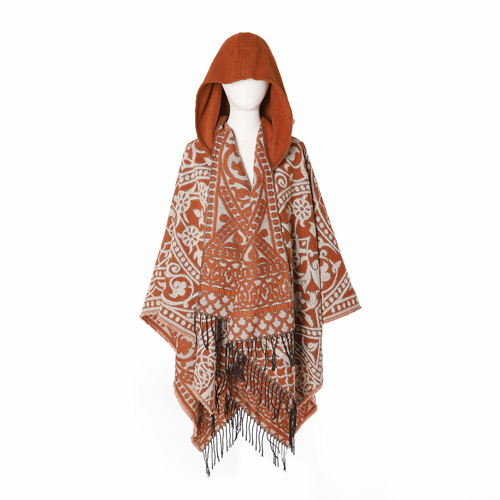 Women’s hooded cape poncho made of wool blend with jacquard pattern, fringes and oversized drape.