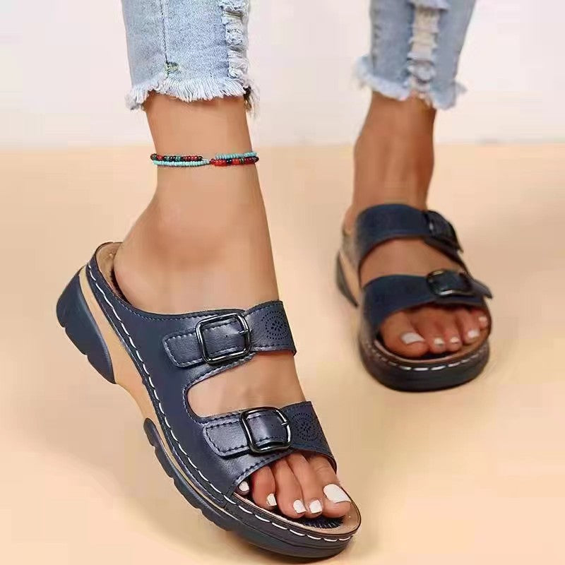 Women's double-strap slide with laser perforation, adjustable metal buckles, and padded wedge footbed Mune Fashion