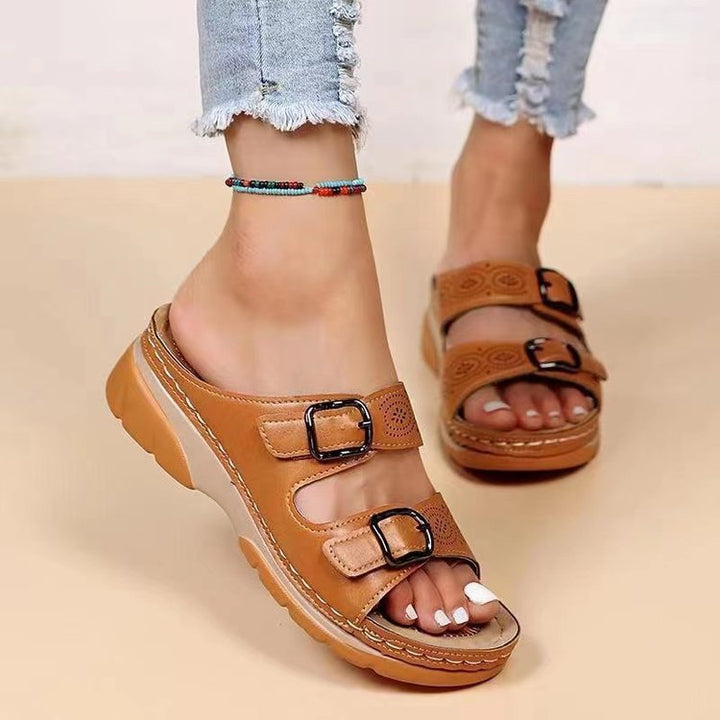 Women's double-strap slide with laser perforation, adjustable metal buckles, and padded wedge footbed Mune Fashion