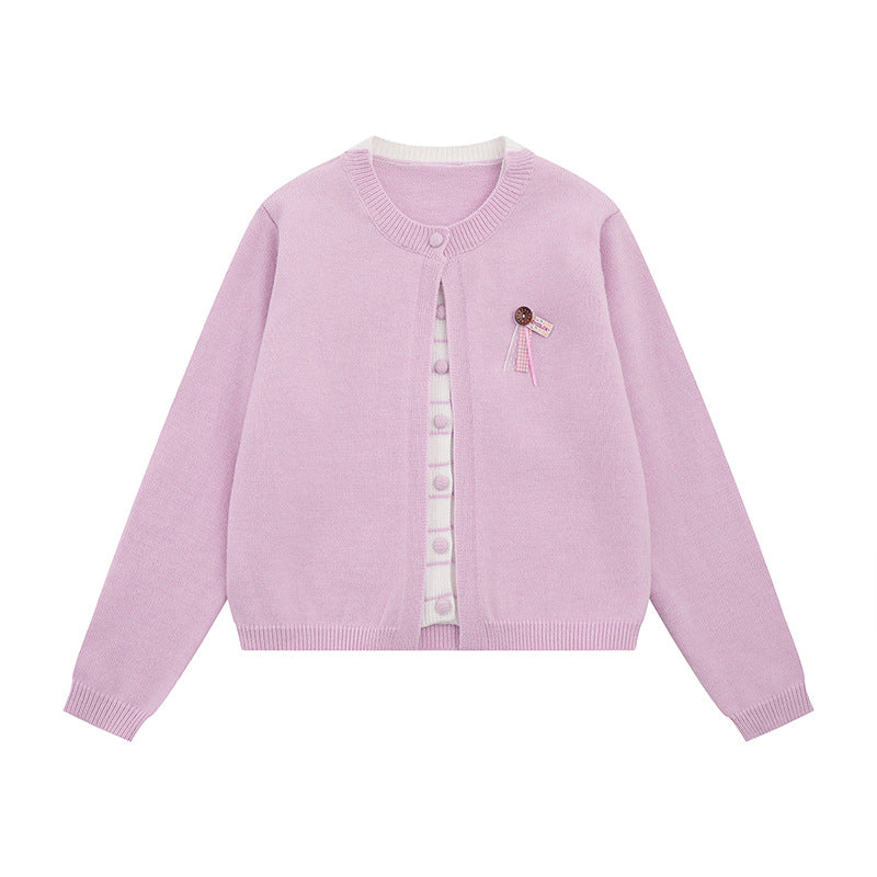 Ladies fine knit cardigan with round neckline, concealed button placket, and decorative brooch Mune Fashion