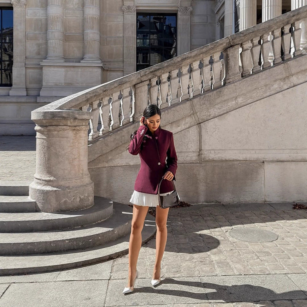 Women's tailored blazer with sculpted waist, asymmetric button detail, and extended hem.