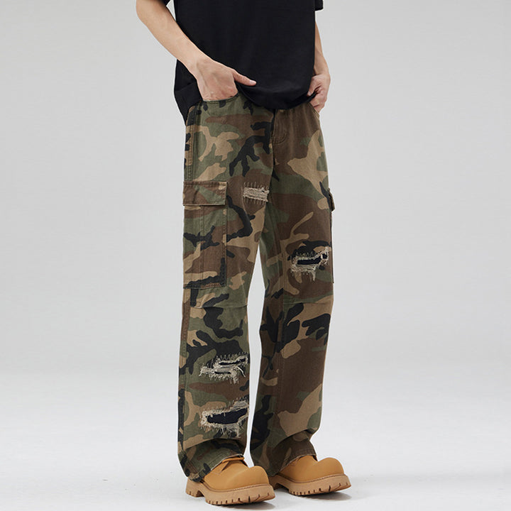 Men's loose cargo pants in camouflage look with deliberately ripped details and large flap pockets Mune Fashion