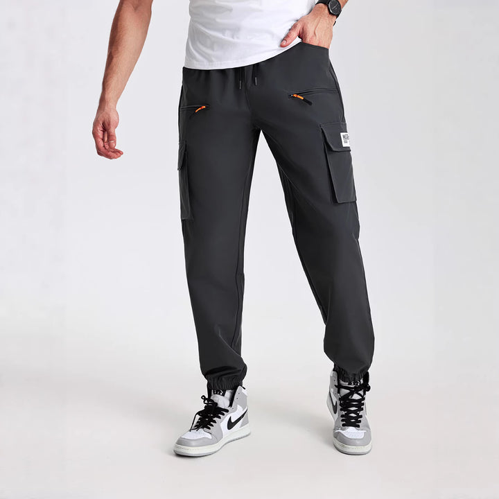Men's tapered cut utility cargo pants in jogger style with drawstring waistband, zippered pockets & elastic leg cuffs Mune Fashion