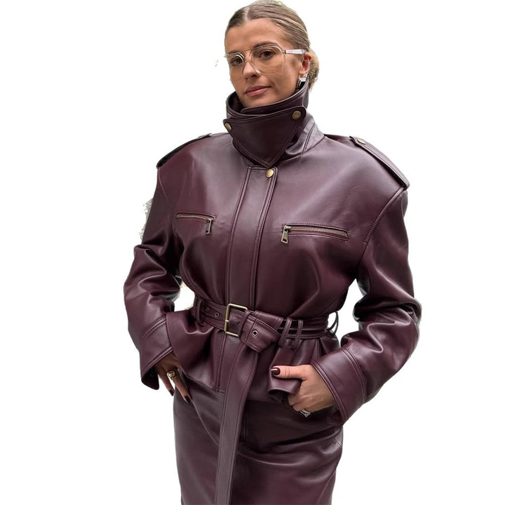 Women's short jacket made of faux leather with a high stand-up collar, fitted tie belt, and prominent shoulder pads Mune Fashion