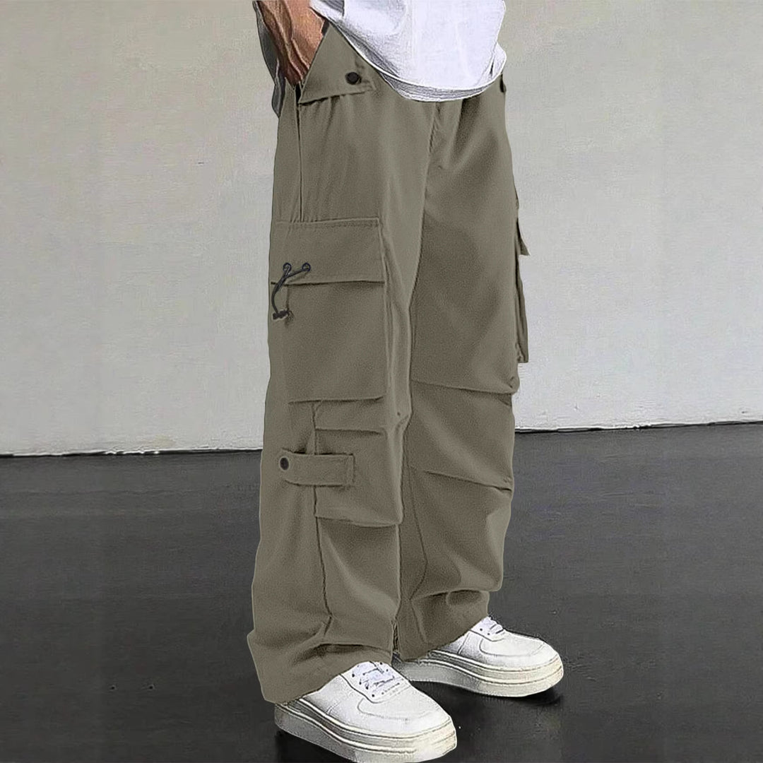 Men's baggy cargo pants with utilitarian flap pockets, drawstring waistband, and reinforced seams Mune Fashion