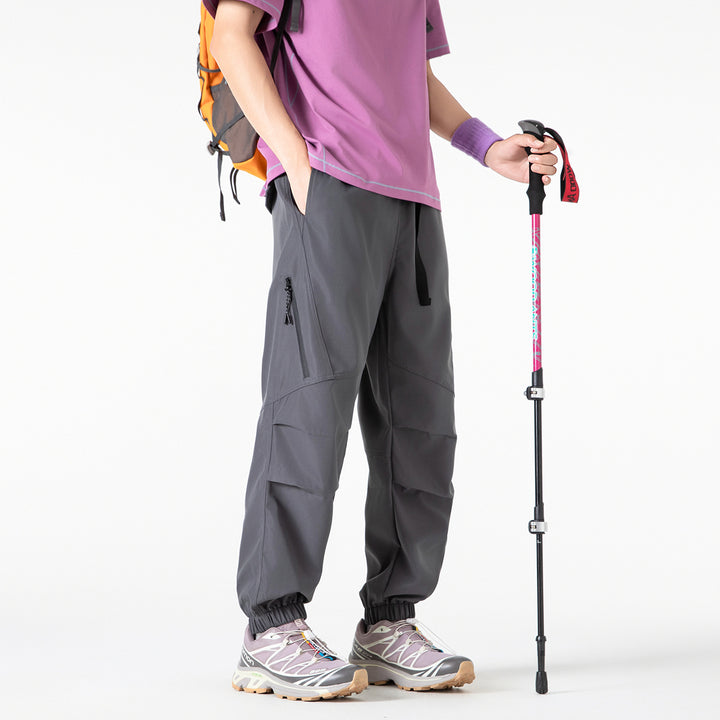 Men's loose technical cargo jogger pants with elastic drawstring waistband, patch flap pockets, and zippered leg pocket Drune