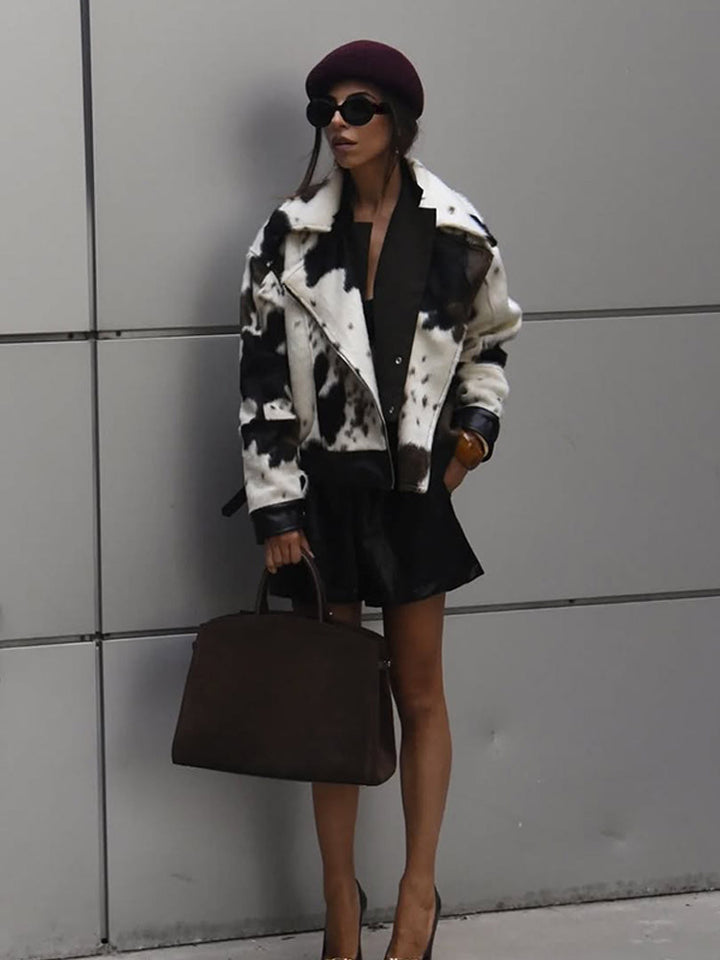 Women short padded biker jacket made of faux fur in cow print with contrast leather trim Mune Fashion