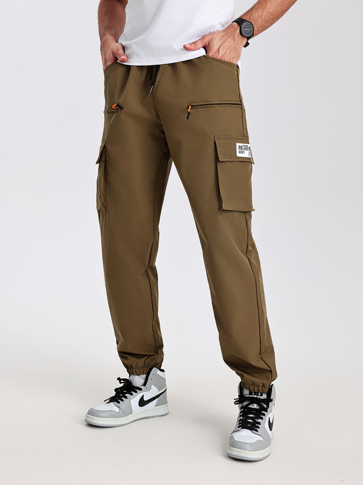 Men's tapered cut utility cargo pants in jogger style with drawstring waistband, zippered pockets & elastic leg cuffs Mune Fashion