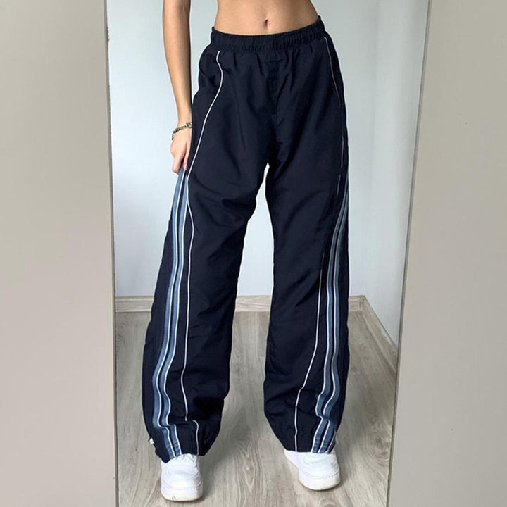 Ladies' sporty training pants with straight leg, elastic comfort waistband, and decorative side piping Mune Fashion