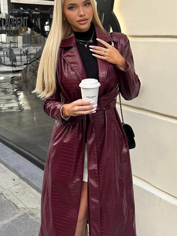 Women's long coat made of faux leather with crocodile embossing and waist belt Mune Fashion