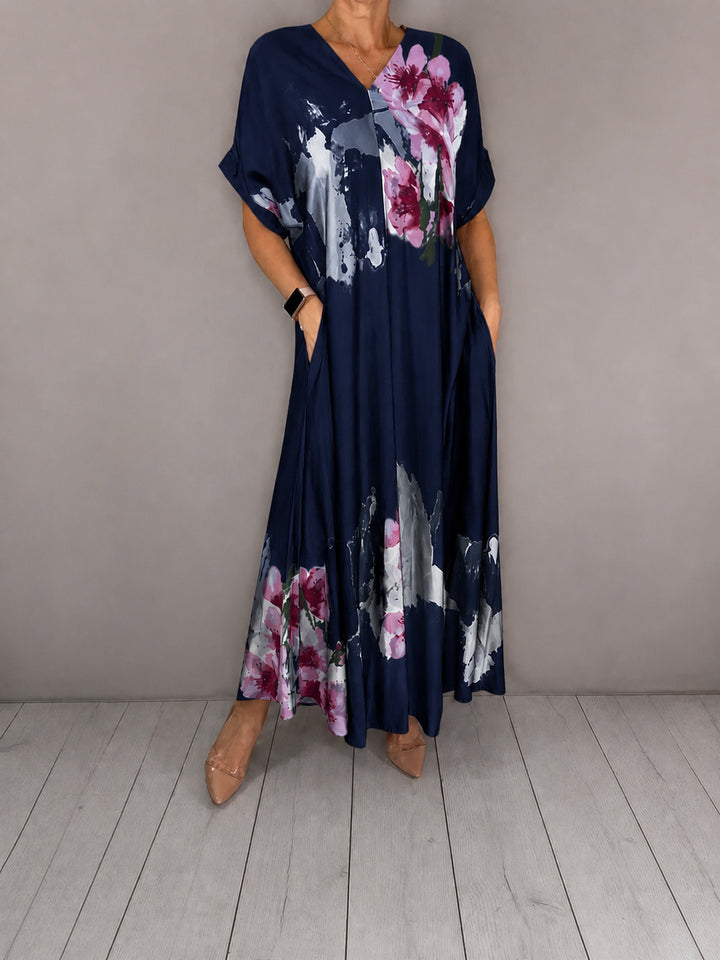 Women's maxi dress with a flowing fall, V-neck, side pockets, and floral watercolor look Mune Fashion