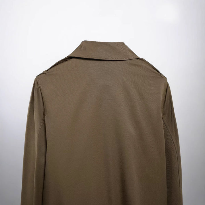Women's short cropped trench coat in boxy cut with double-breasted button placket, shoulder epaulets and adjustable sleeve straps Mune Fashion