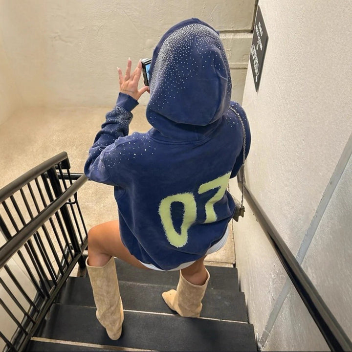 Women's oversized hoodie made of velvet fleece with distinctive logo print, glitter trim, and kangaroo pocket Mune Fashion