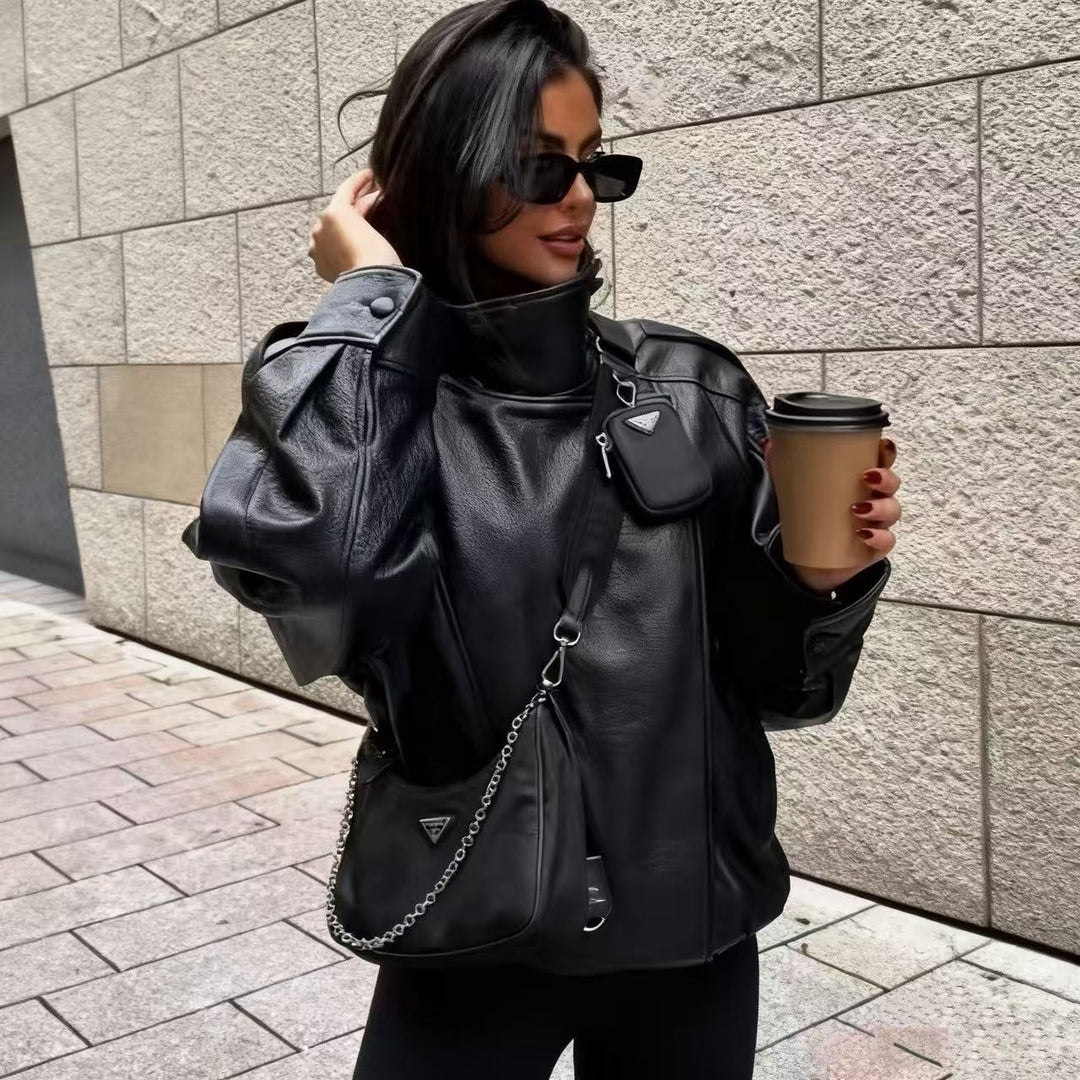Women's oversized faux leather jacket with high standing collar, asymmetric button placket, shoulder flaps, and elastic hem Mune Fashion