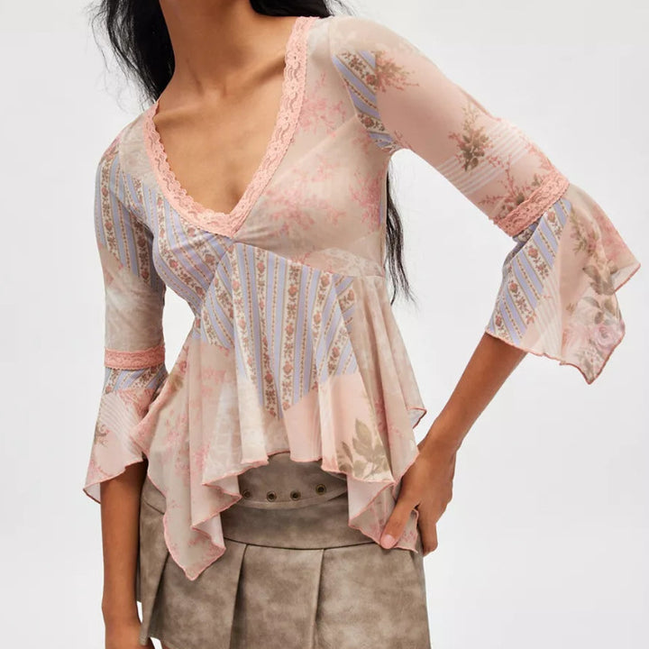 Ladies sheer mesh top with V-neck, lace trim, asymmetric ruffle hem, and bell sleeves Mune Fashion