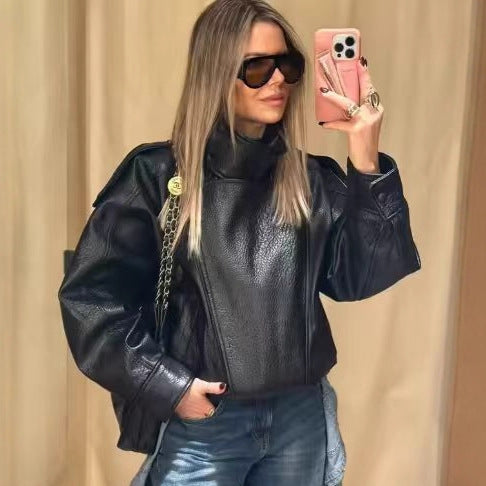 Women's oversized faux leather jacket with high standing collar, asymmetric button placket, shoulder flaps, and elastic hem Mune Fashion
